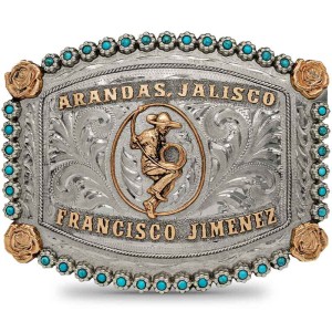 A custom silver and turquoise belt buckle adorned with golden bronze roses, a mexican charro figure and Arandas, Jalisco lettering 